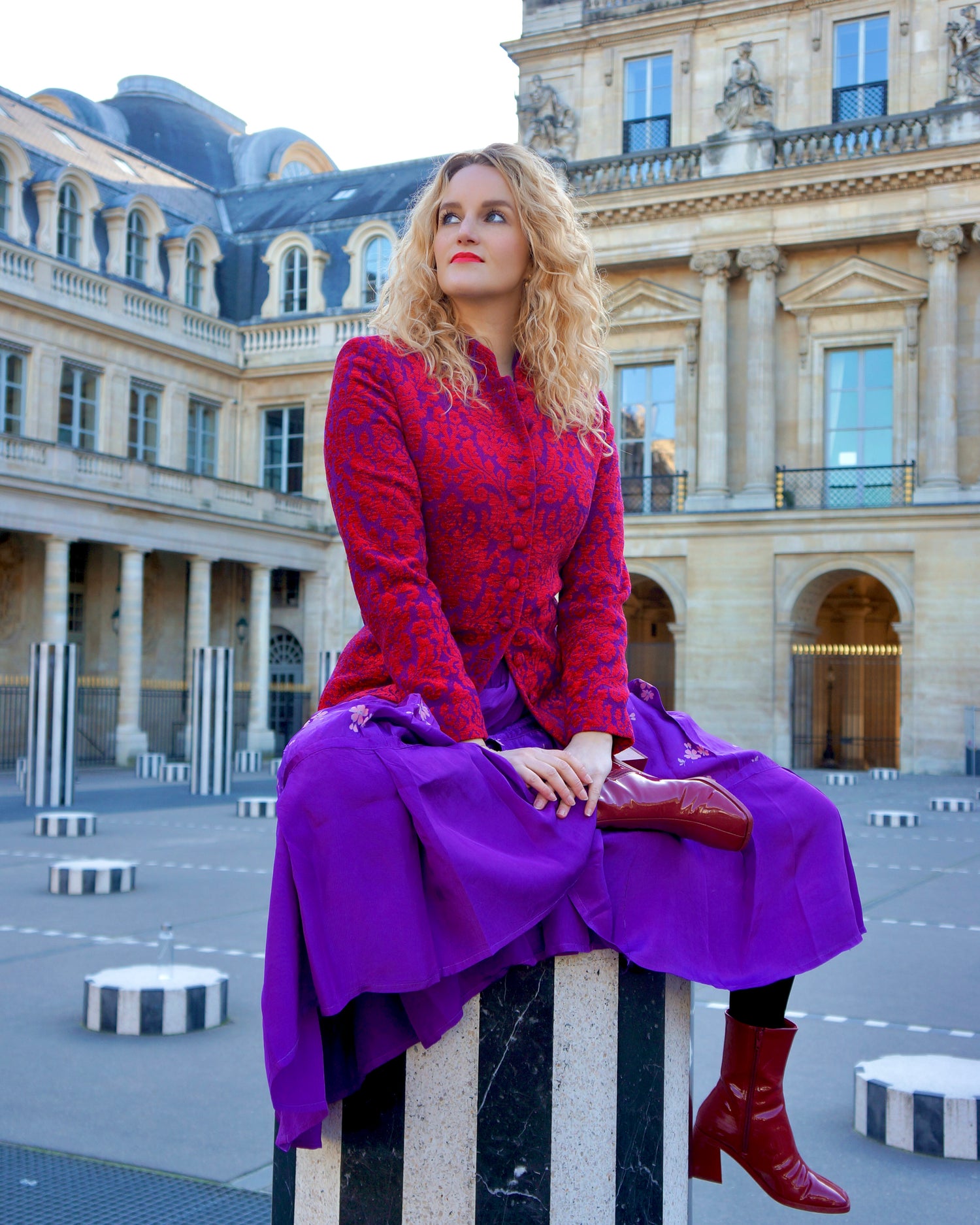 Blonde vrouw in Parijs draagt een kleurrijke vintage outfit bij Palais Royal